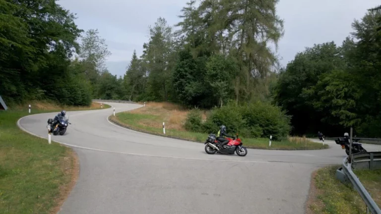 Motorrijders nemen een haarspeldbocht tijdens een motorrit in de bergen