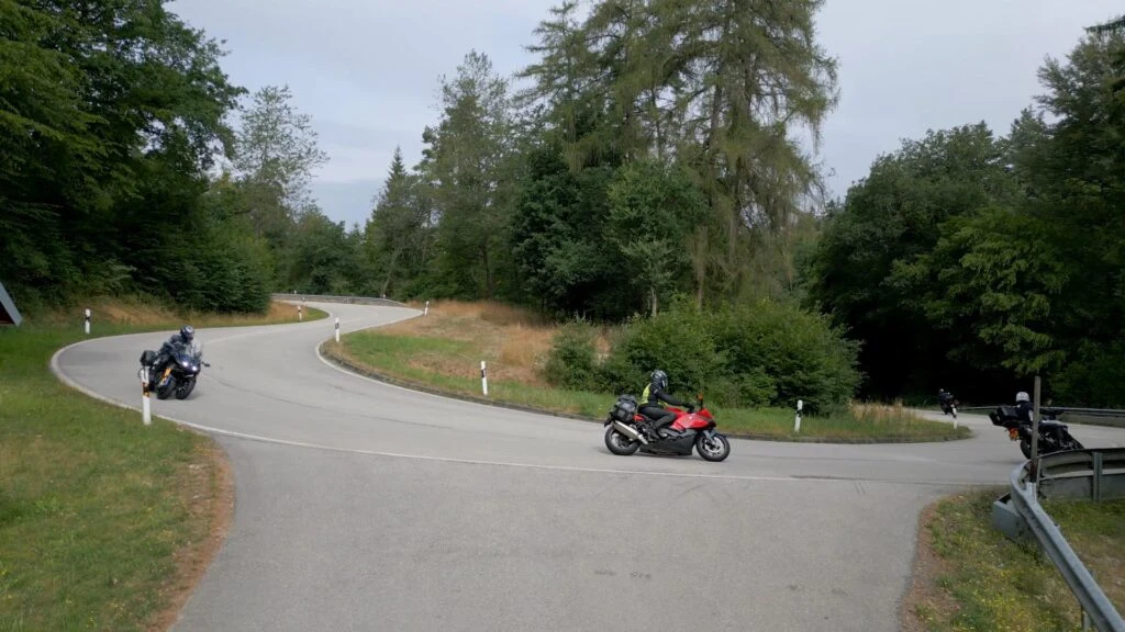 Motorrijders nemen een haarspeldbocht tijdens een motorrit in de bergen