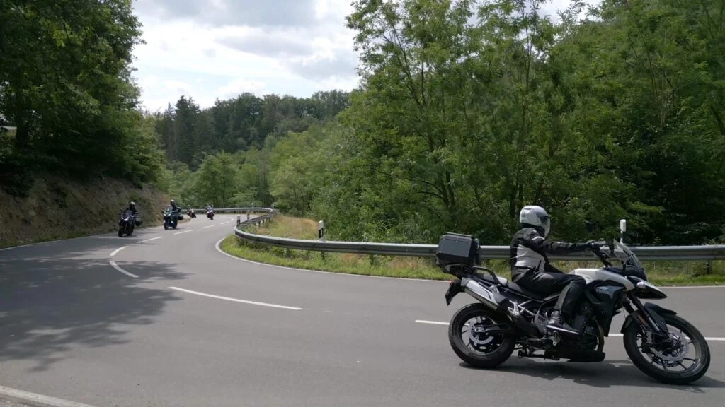 Groep motorrijders rijdt door een bochtige bergweg