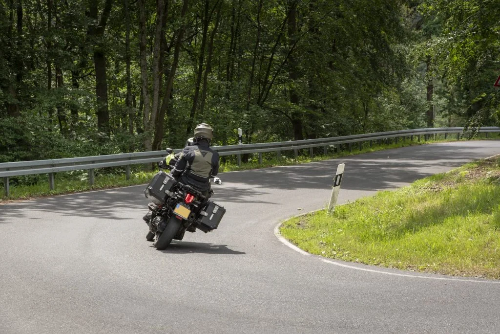 Motorrijder stuurt door een scherpe bocht in de bergen